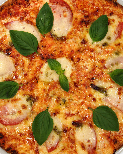 Pizza Mozzarella mit Tomaten und frischem Basilikum, nah von oben